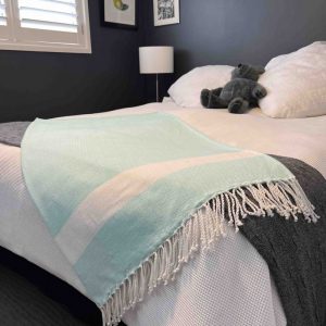 Aquamarine towel draped over a bed