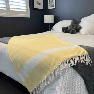 Yellow towel draped over a bed