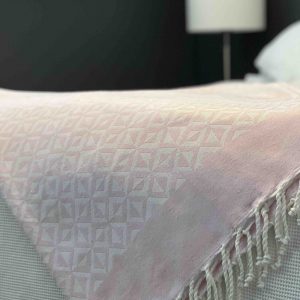 Light pink towel draped over a bed